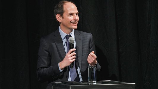 Jubiläumsveranstaltung 60 Jahre OeAD, Ein Mann hinter dem Podium, mit einem Mikrofon in der Hand