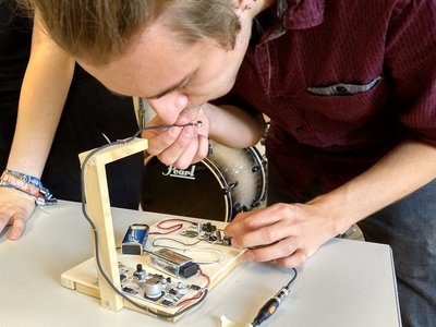 A young man works on a digital musical instrument