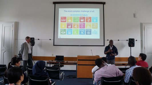 picture show Paul Yillia from the IIASA who is talking to the visitors about the Sustainable Development Goals