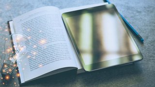 Tablet, Schulbuch und Glühbirne