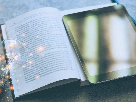 Tablet, Schulbuch und Glühbirne