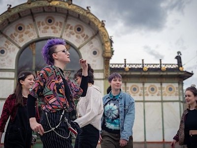 Eine Gruppe junger Menschen vor der Otto-Wagner-Station am Wiener Karlsplatz. Sie gehen herum.