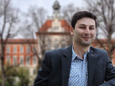 Portrait of Alumnus Tigran Keryan in front of an university building 