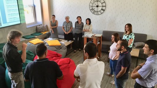 Group of people standing in a circle in front of a presentation