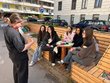 Mehrere Personen sitzen und betrachten eine stehende Person, die eine Aufgabe erklärt