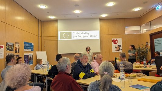 Gruppe an Menschen sitzt an Tischen