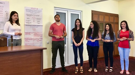 Group of people standin in front of posters presenting something