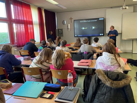 Forscher hält Präsentation vor Schülerinnen und Schüler in der Klasse