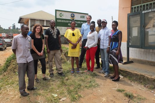 Group of people standning in front of a house and an APPEAR project sign