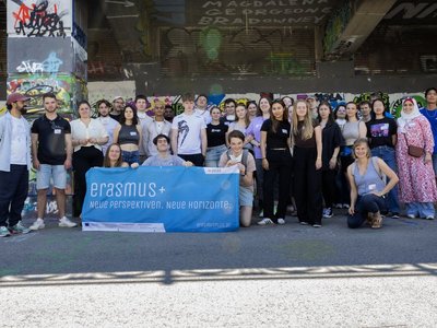 Gruppe junger Menschen halten Erasmus+ Flagge