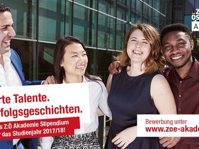 Ein Mann und drei Studenten stehen vor einem Universitätsgebäude.