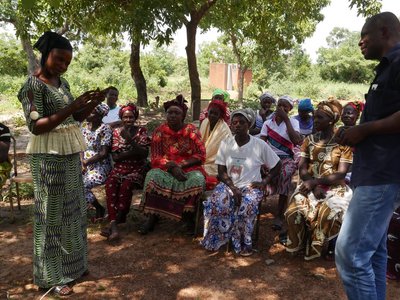 Group of sitting people looking at a standing woman and man