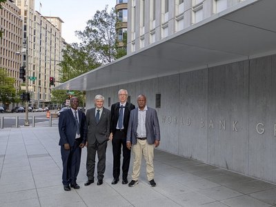 Project team members posing for a group picture in front of the World Bank