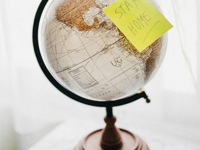 Globus mit Post it Aufschrift "Stay home"