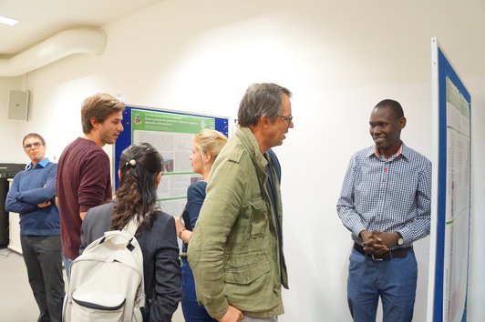 Group of people discussing and looking at the posters of the poster presentation