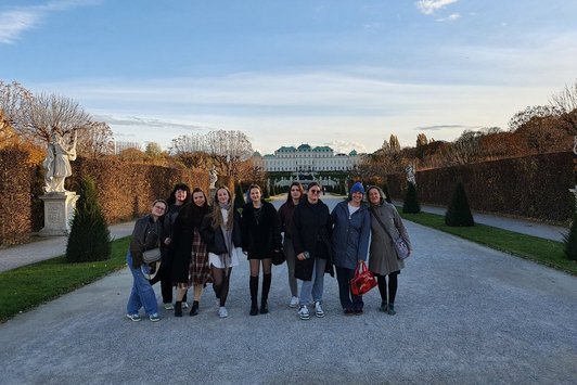 Ein Gruppenfoto im Freien im Herbst, im HIntergrund das Schloss Belvedere