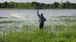 Fisherman fishing with net from behind