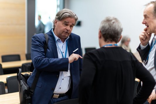 Three participants talk during the coffee break