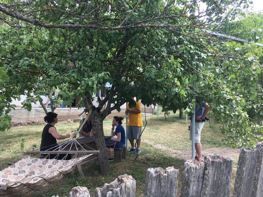 Group of people sitting at a table under trees