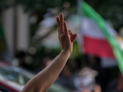 Hand in der Luft vor iranischer Flagge