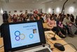 Laptop stands in front of a well-filled hall in the OeAD building: large crowds of visitors at the event.