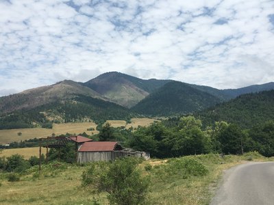 Remains of a wooden house in the midst of green hilly landscape