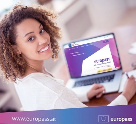 Eine Dame sitzt an einem Laptop auf dem die Europass Website geöffnet ist.