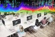 Schülerinnen sitzen vor Computern, über ihnen sind bunte Datengrafiken über das Bild gelegt 