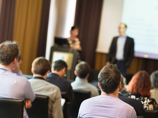 Das Bild zeigt eine Konferenzsituation.