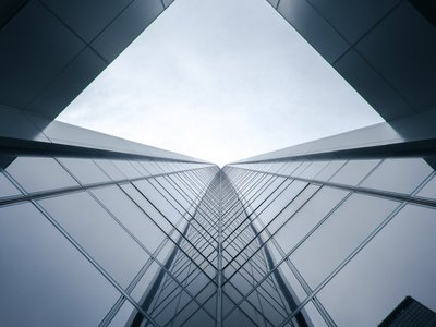 Blick von unten hinauf auf ein Hochhaus aus Glas