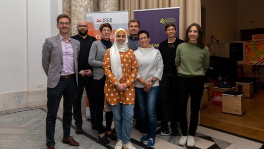 Gruppenfoto mit Antisemitismus-Experten, vor zwei Bannern (eines vom OeAD und das andere vom hdGö) in einem Raum mit hoher Decke.