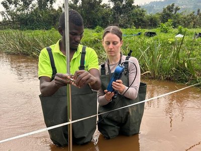 Students conducting stream discharge measurements using the newly acquired OTTHYDROMET current meter (Model 1600000721) during fieldwork in the Kigezi Highlands.