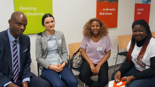 One man and three women sitting on chairs