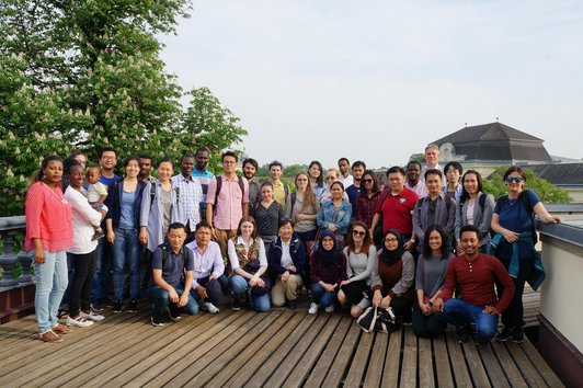 About thirty participants posing for a group picture in one of the premises of the Laxenburg park and the IIASA institute