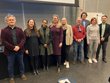 Gruppenbild mit neun Menschen, davon vier Männer und fünf Frauen, in einem Hörsaal vor dem Pult.