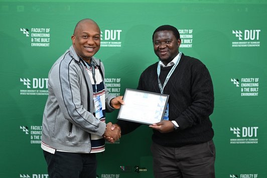 Photo of Vianney Kambale receiving the Best Paper Award at the IEEE ICTAS Conference