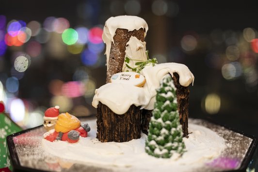 Weihnachtsdekoration in Form eines verschneiten Haues mit Tannenbaum und Weihnachtsmann.