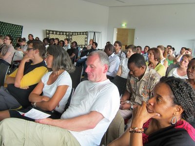 Group of people sitting arranged in rows and looking at something in front of them