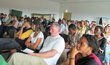 Group of people sitting arranged in rows and looking at something in front of them