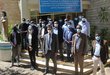 A group of researchers wearing face masks standing in front of a university building