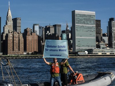 Greenpeace activists are protesting on a boat in front of New York's skyline 