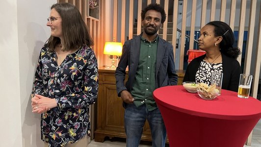 Three people standing around a table