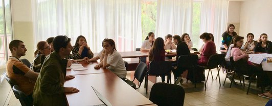 Three groups of people each sitting together at seperate tables