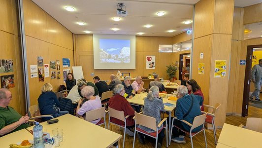 Gruppe an Menschen sitzt an Tischen