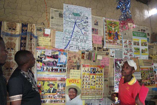 Three Men in front of a wall with many posters on it