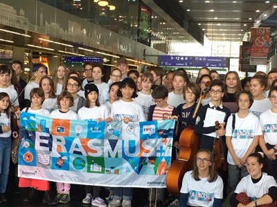 Group photo with school children holding a banner with the word Erasmus.