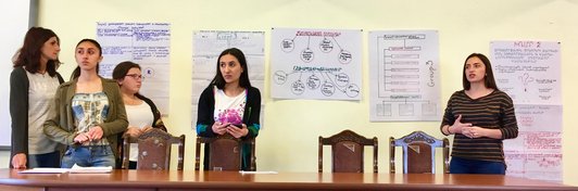 Group of women standing in front of posters with written information