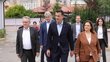 Vienna State Parliament President Ernst Woller, Mayor of Tirana Erion Veliaj and school principal H. Gjoni, followed by Austria's ambassador to Albania Christian Steiner and OeAD managing director Jakob Calice. Everyone is walking along a path towards a building that is not visible in the picture.