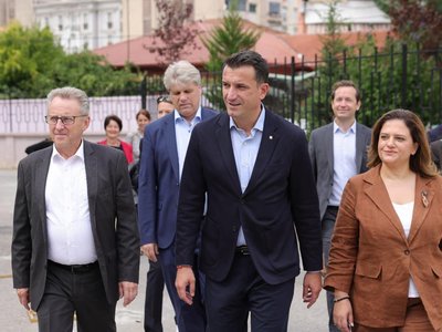 Vienna State Parliament President Ernst Woller, Mayor of Tirana Erion Veliaj and school principal H. Gjoni, followed by Austria's ambassador to Albania Christian Steiner and OeAD managing director Jakob Calice. Everyone is walking along a path towards a building that is not visible in the picture.