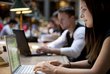 A young woman types on her laptop in the reading room at the University of Vienna